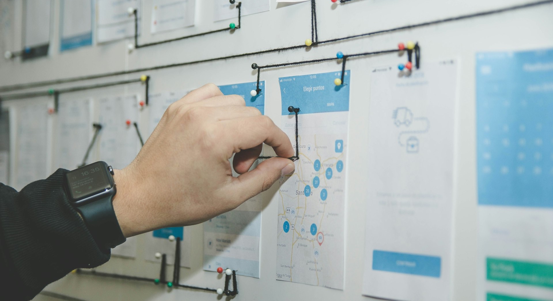 person working on blue and white paper on board