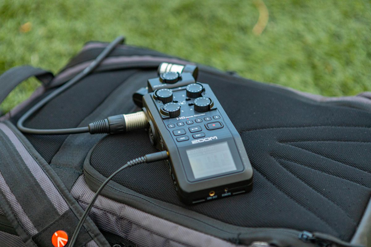 Close-up of a portable audio recorder on a backpack, ideal for outdoor recording.