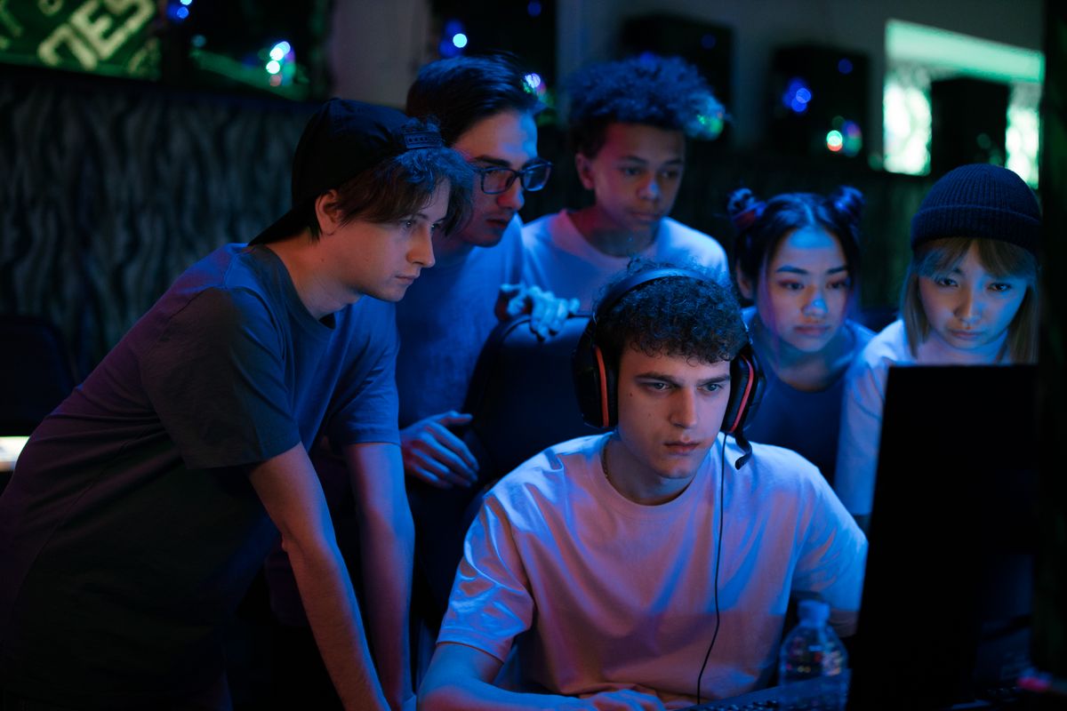 Group of diverse teenagers gaming together indoors, intense and focused.